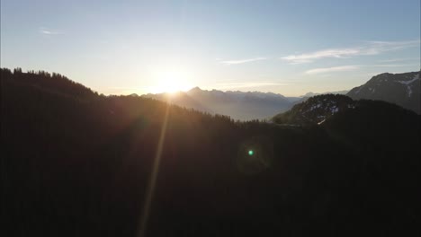 Aerial-view-of-Sunrise-behind-Snow-Covered-Mountain-Range-in-the-Alps,-Bludenz,-Austria,-Europe