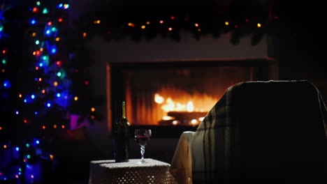 n empty armchair stands by the fireplace everything is decorated with christmas garlands