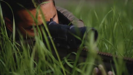soldier aiming with a sniper rifle in the grass