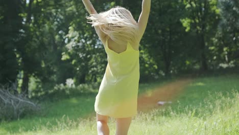 woman in yellow dress dancing gracefully in summer park