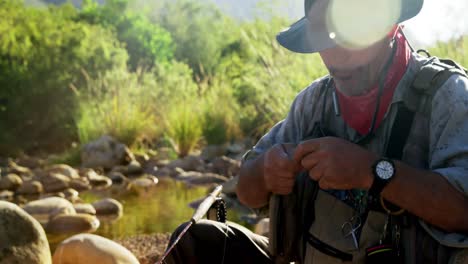 fly fisherman preparing string to tie on hook