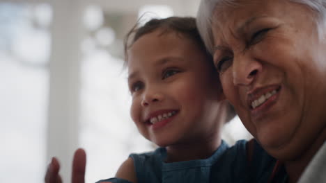 cute little girl hugging grandmother smiling embracing her granddaughter happy granny enjoying hug from her grandchild at home family concept 4k