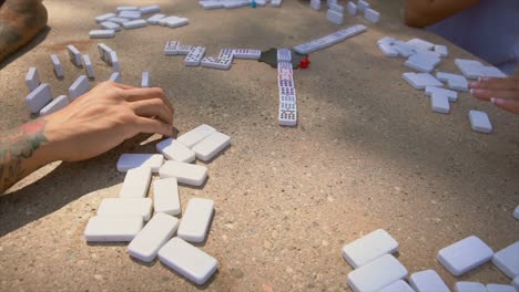 close-up time lapse of a group of people playing dominos together at the park