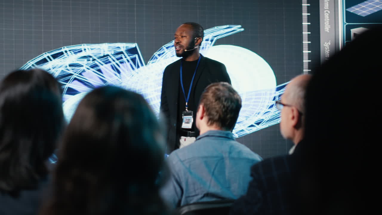 Male speaker hosts heavy industrial presentation with turbines and gear systems