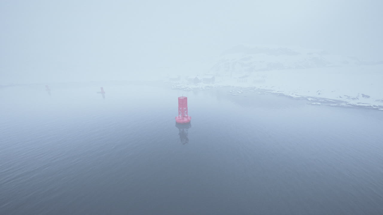Foggy View of Snowy Coastline with Red Buoy