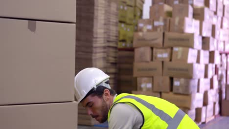 warehouse worker packing up palette of boxes