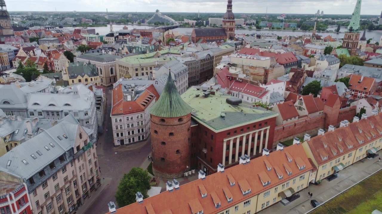 Drone si alza sopra la Torre delle Polveri rivelando i tetti della Città Vecchia di Riga e le guglie delle chiese.