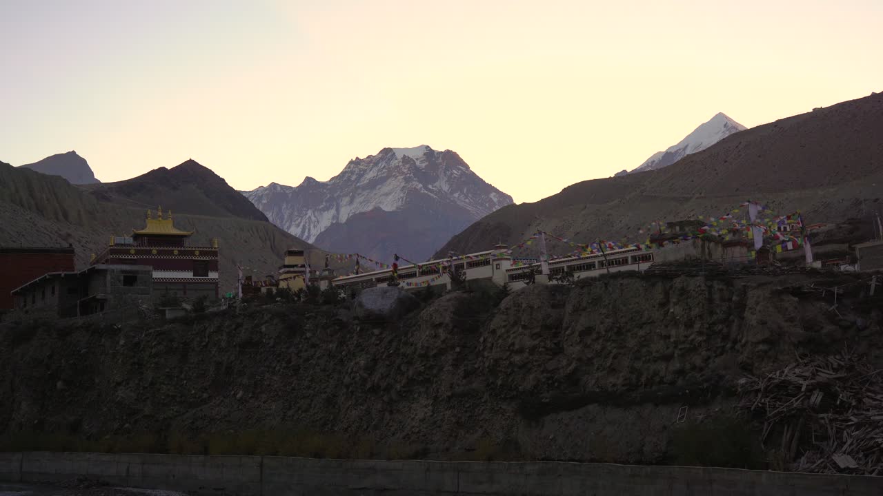 una vista del templo budista en kagbeni, nepal con las banderas de oración ondeando en el viento