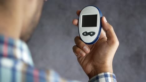 person checking blood sugar level with glucose meter