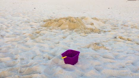 Verlassener-Eimer,-Der-Im-Sand-Lag,-Neben-Wo-Kinder-Am-Strand-Spielten