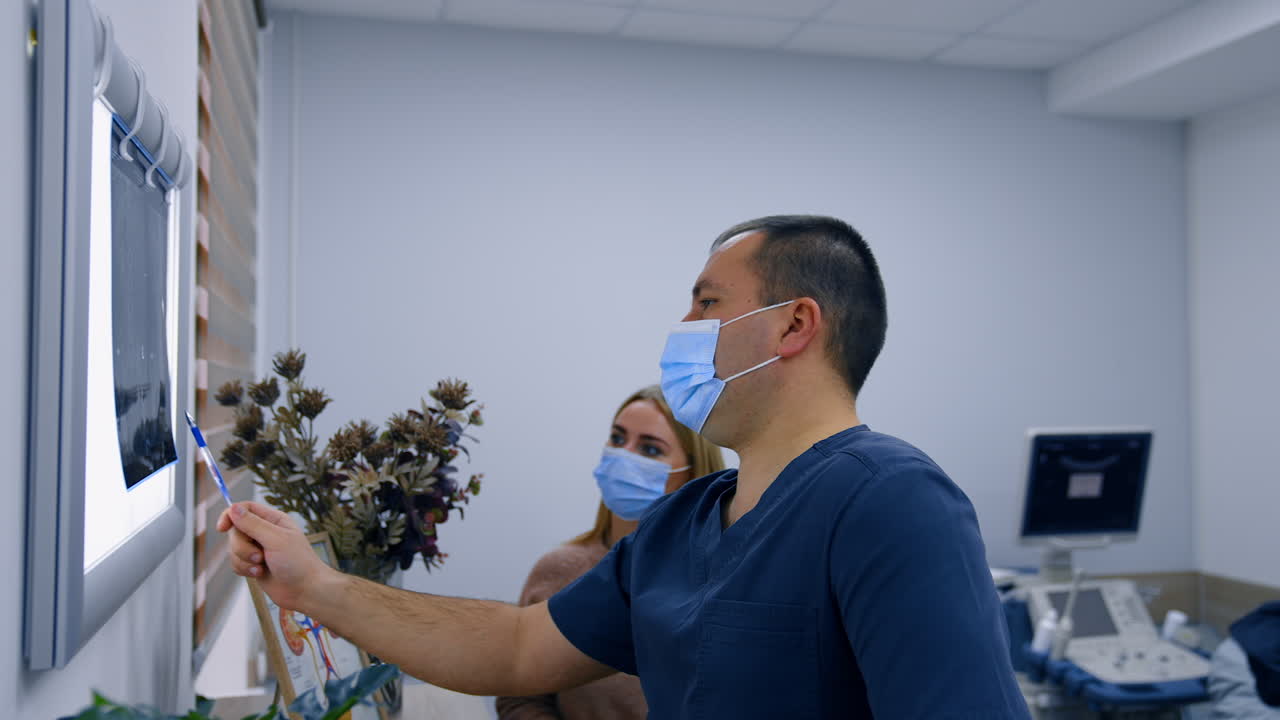 Professional doctor talking to a female patient explaining the x-ray scan. Analyzing health tests and checkups in hospital.