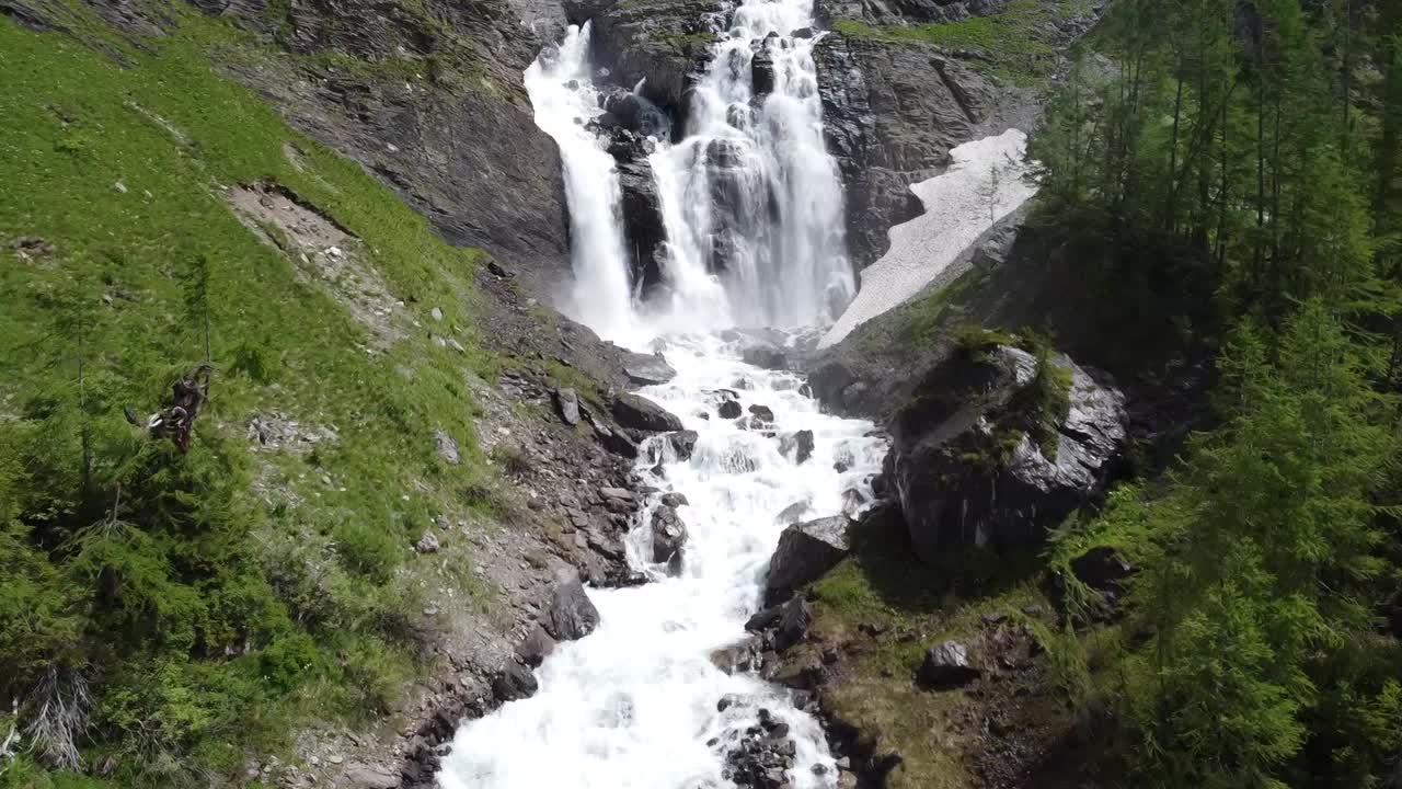 Drone flight to a breathtaking large waterfall in the swiss alps
