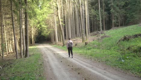 Una-Mujer-De-Unos-25-Años-Viaja-Sola-Con-Una-Mochila-Por-El-Bosque-En-Primavera