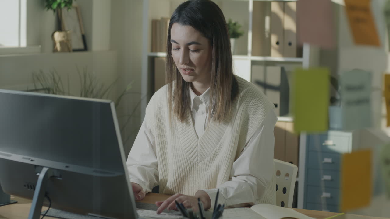 mujer trabajando en computadora en una oficina moderna