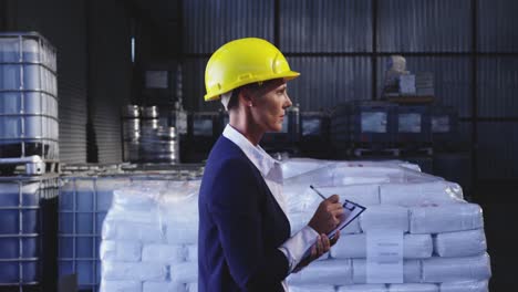 Female-warehouse-manager-checking-stock-in-storeroom-4k