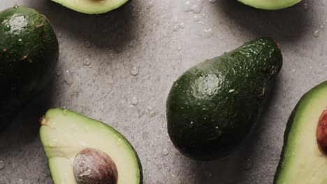 Micro-video-of-close-up-of-avocados-with-copy-space-on-grey-background