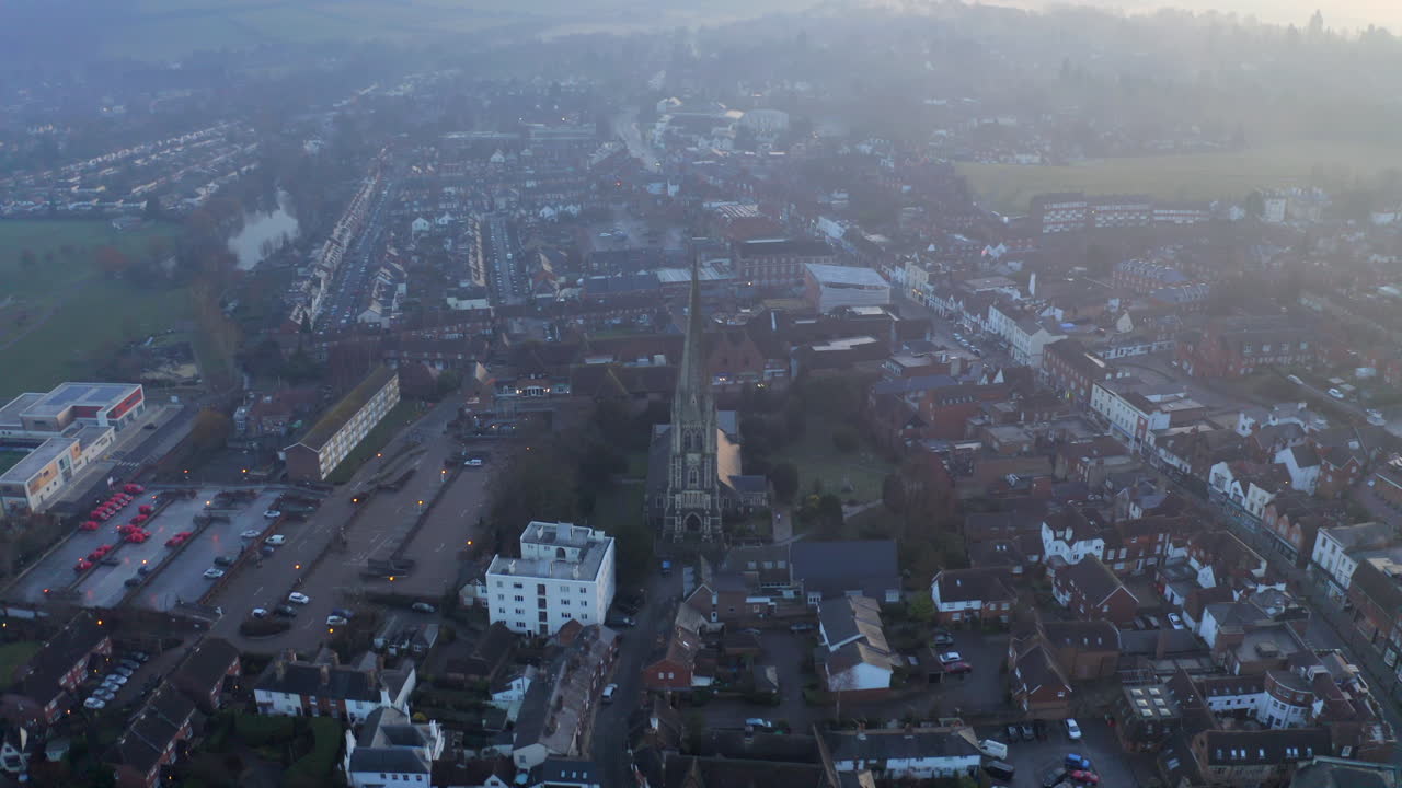 안개 낀 아침 서리에 있는 도킹에 있는 오래된 영국 교회 위로 날아가는 공중 샷