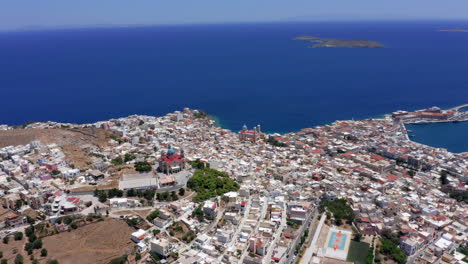 Aerial:-Slow-panoramic-panning-drone-shot-of-Ermoupoli-city-in-Syros-island,-Greece-on-a-sunny-day