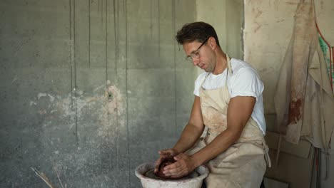 master potter gives shape on old manual potter's wheel. makes crockery concept