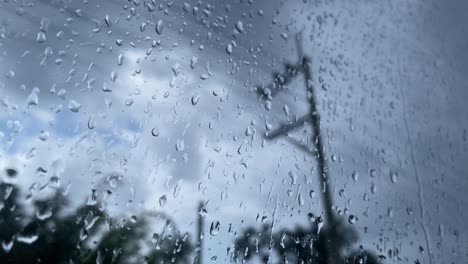 Droplets-linger-on-a-glass-surface-reflecting-power-lines-on-a-rainy-day