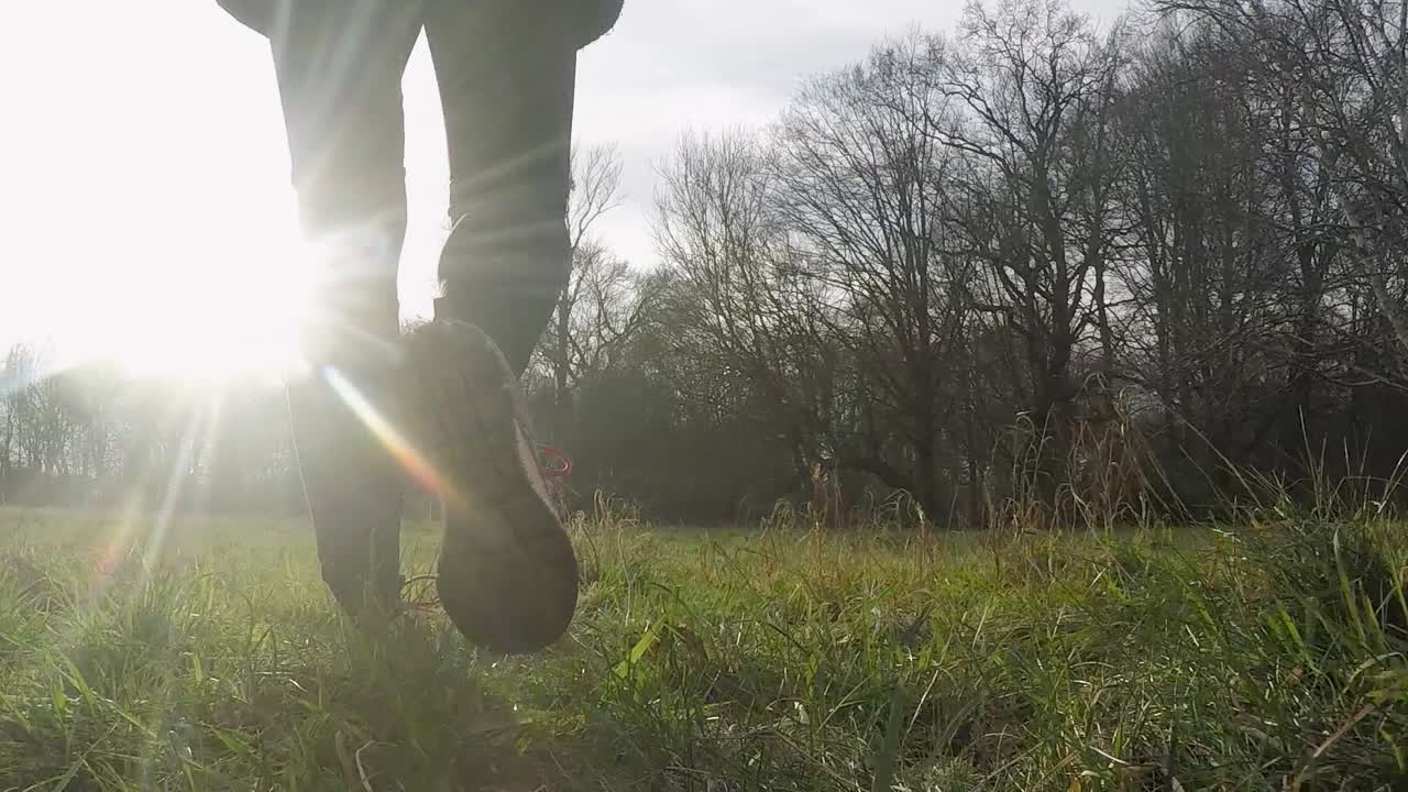 스포츠 의류 를 입은 여자 가 이슬 이 있는 아침 잔디 를 고 있다