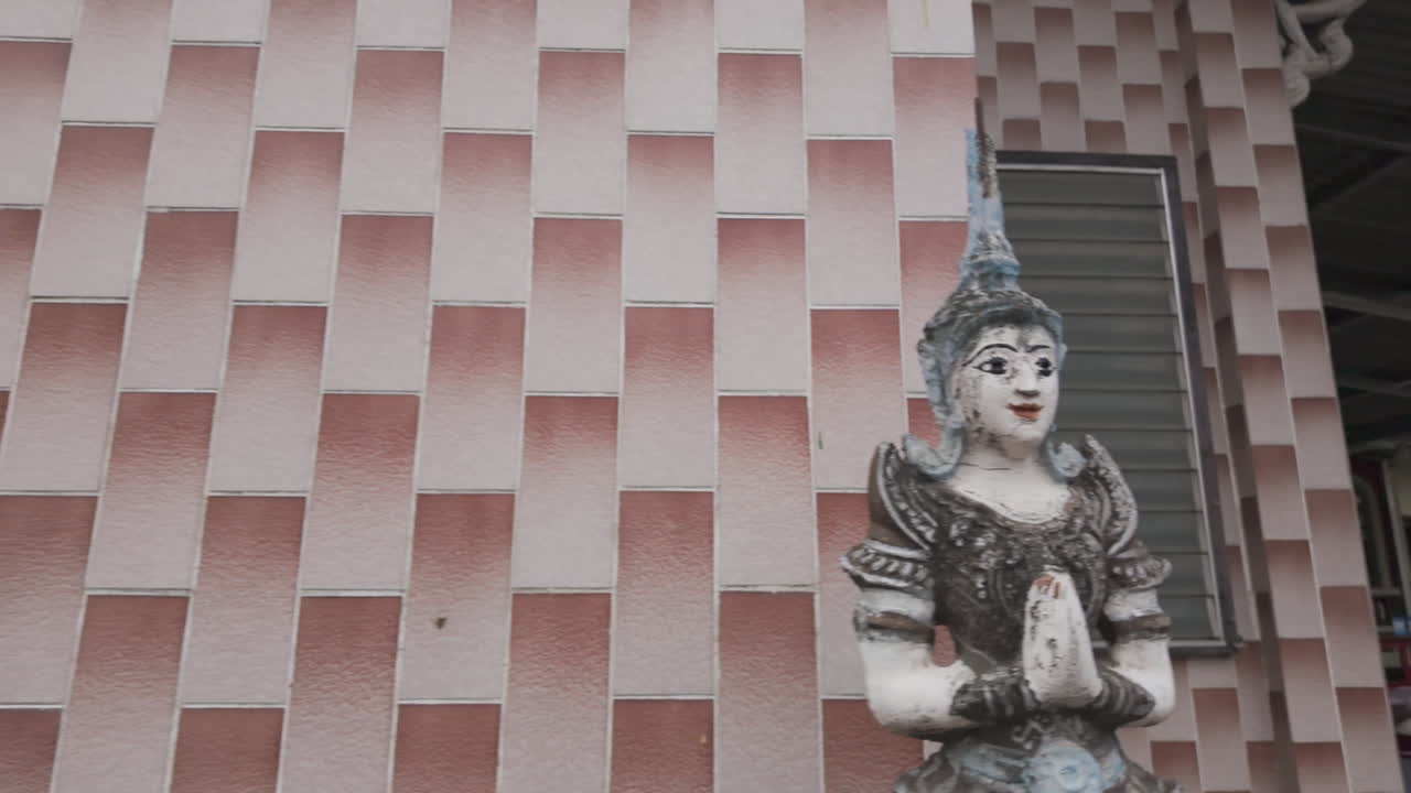Ornate Kinnara Statues Against Tiled Wall At Wat Muen Ngoen Kong Temple In Chiang Mai, Thailand. sliding shot