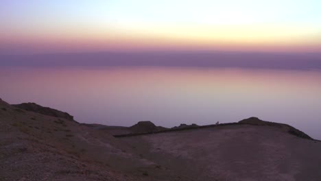 a purple golden glow after sunset behind the dead sea in jordan