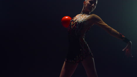 hermosa gimnasta usando la pelota en el interior mujer encantadora haciendo gimnasia rítmica