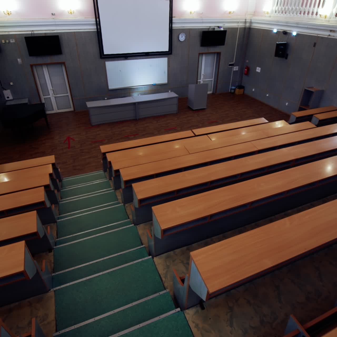 Modern hall for meetings. Large university auditorium with row of desks and a large white board. Empty classroom