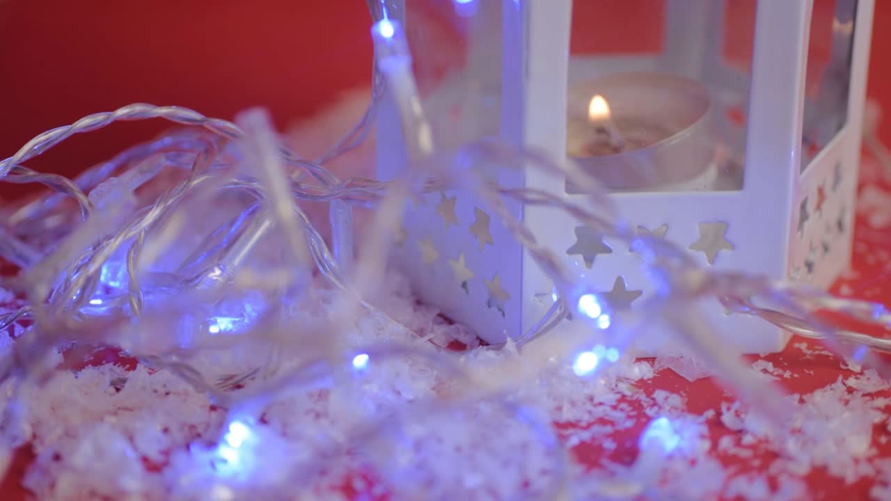 fondo de luces de navidad con linterna de vela sobre fondo rojo.