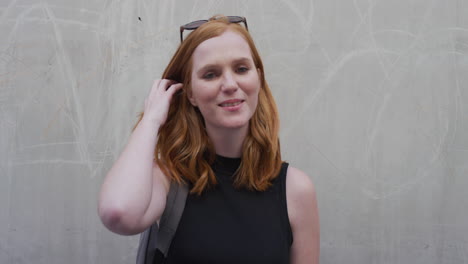 portrait beautiful young red head woman smiling happy running hand through hair looking confident enjoying lifestyle