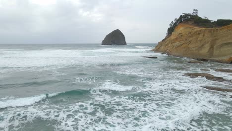 Aerial-view-of-a-beautiful-beach-in-Oregon,-ocean-waves-rolling-into-shore