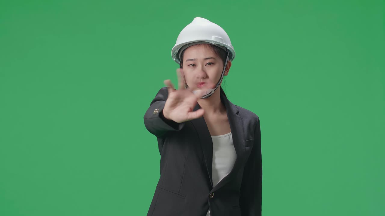 Upset Asian Female Engineer Showing Gesture Hands Palm And Waving While Shaking Head In The Green Screen Studio