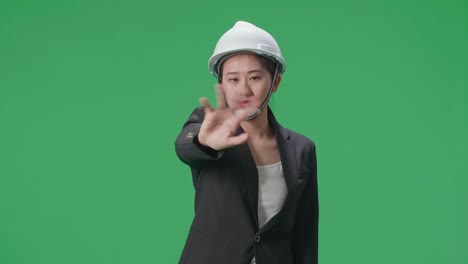 upset asian female engineer showing gesture hands palm and waving while shaking head in the green screen studio