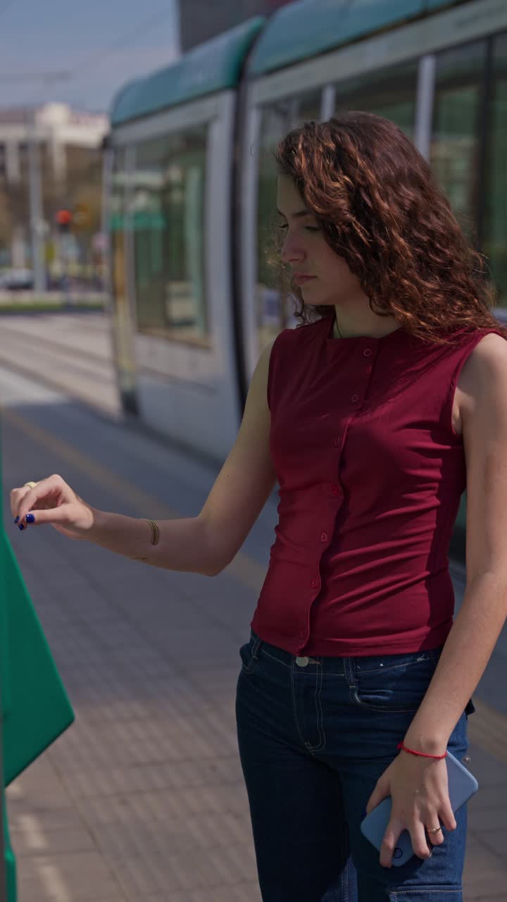 Giovane donna al distributore automatico di biglietti del trasporto pubblico