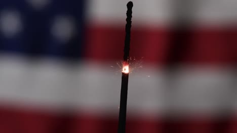 video of close up of sparkler with copy space over flag of usa