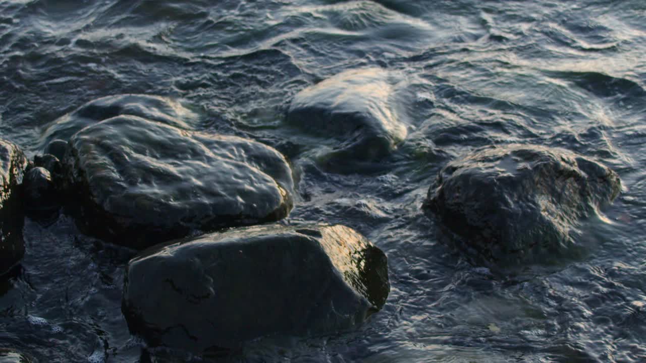 Waves crashing at the rocks on the beach at daylight