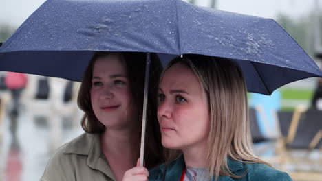 two women under an umbrella in the rain