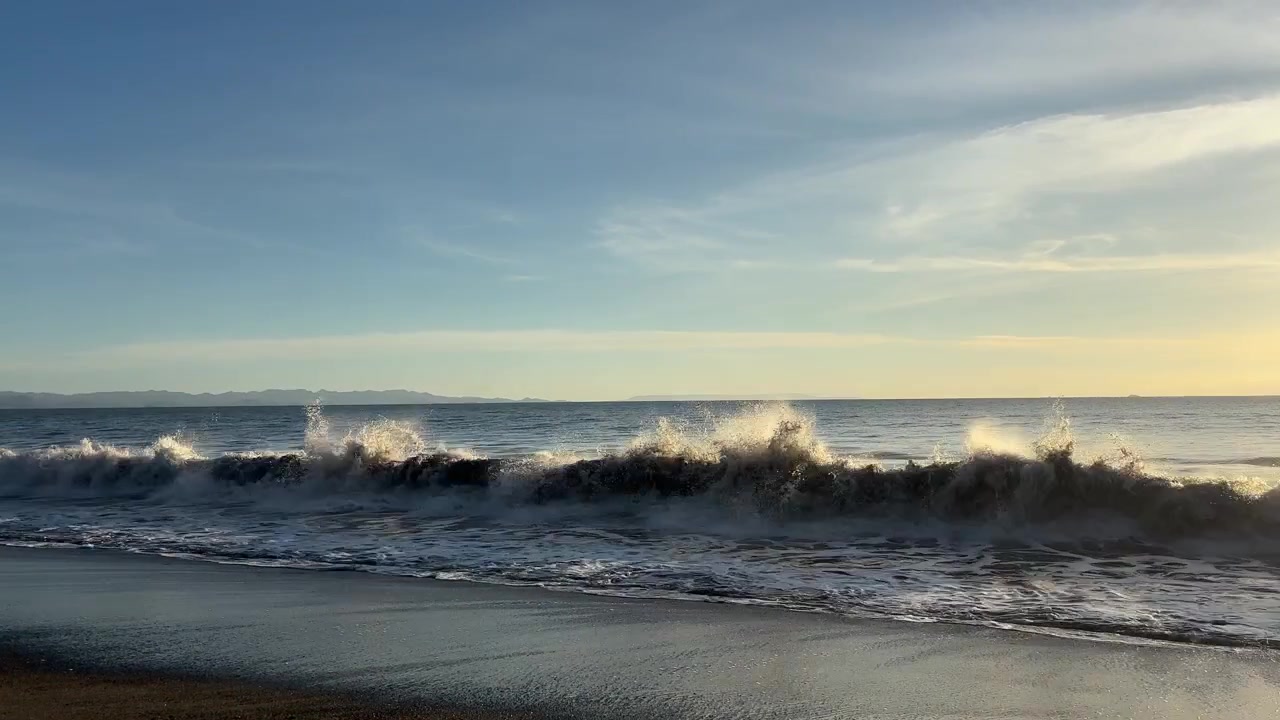 Onde dell'oceano che si infrangono dolcemente su una spiaggia sabbiosa al tramonto