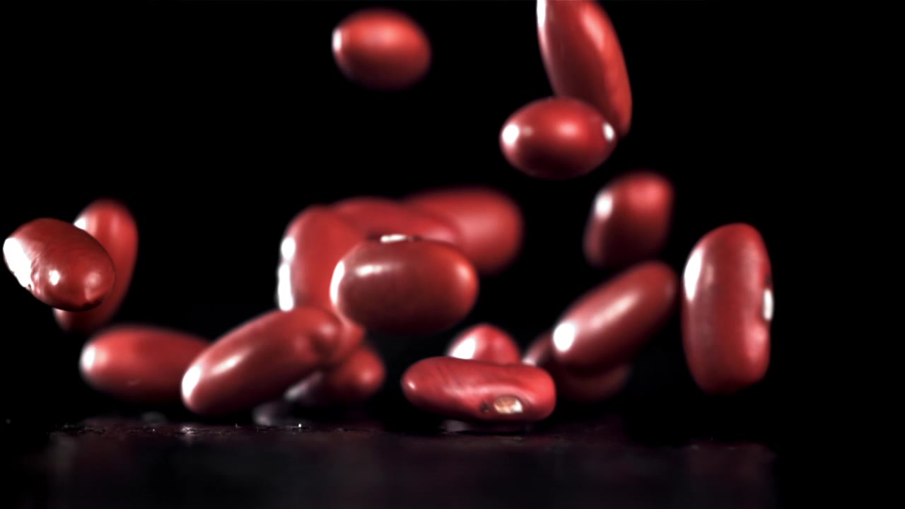 Red Kidney Beans Falling in Slow Motion on a Black Background