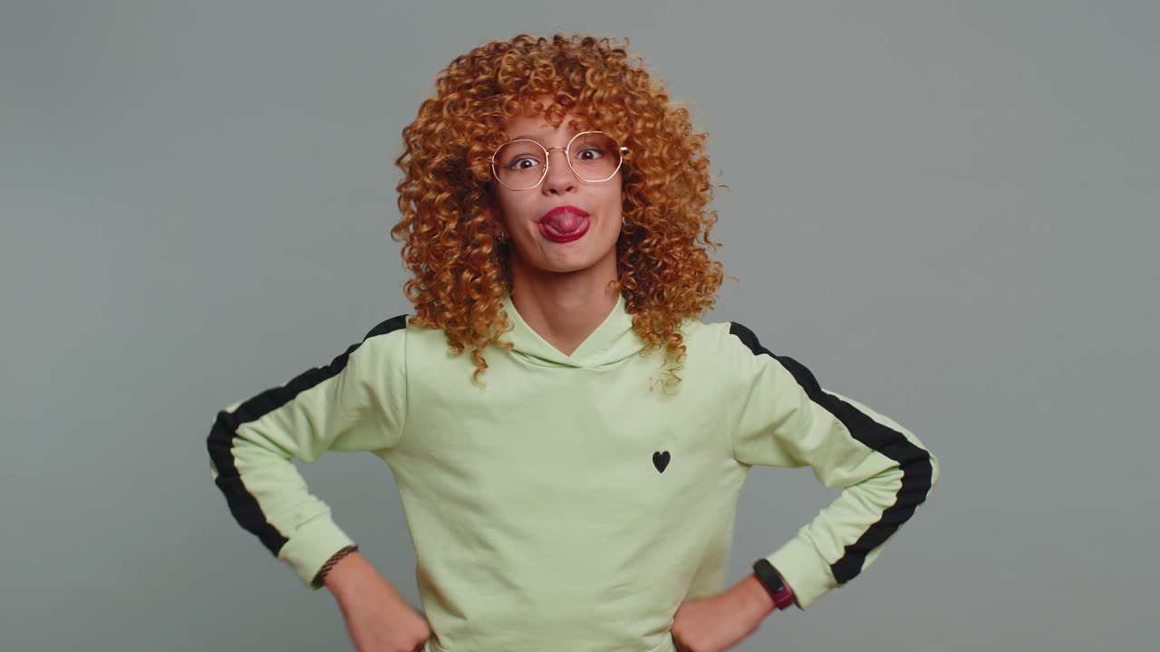 alegre divertida niña matona mostrando la lengua haciendo caras tontas haciendo tonterías bromeando burlándose