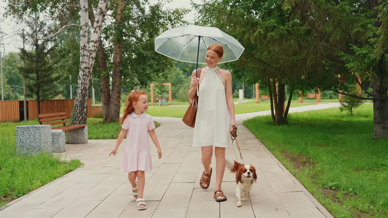 Mother, Daughter, and Dog in a Park on a Rainy Day