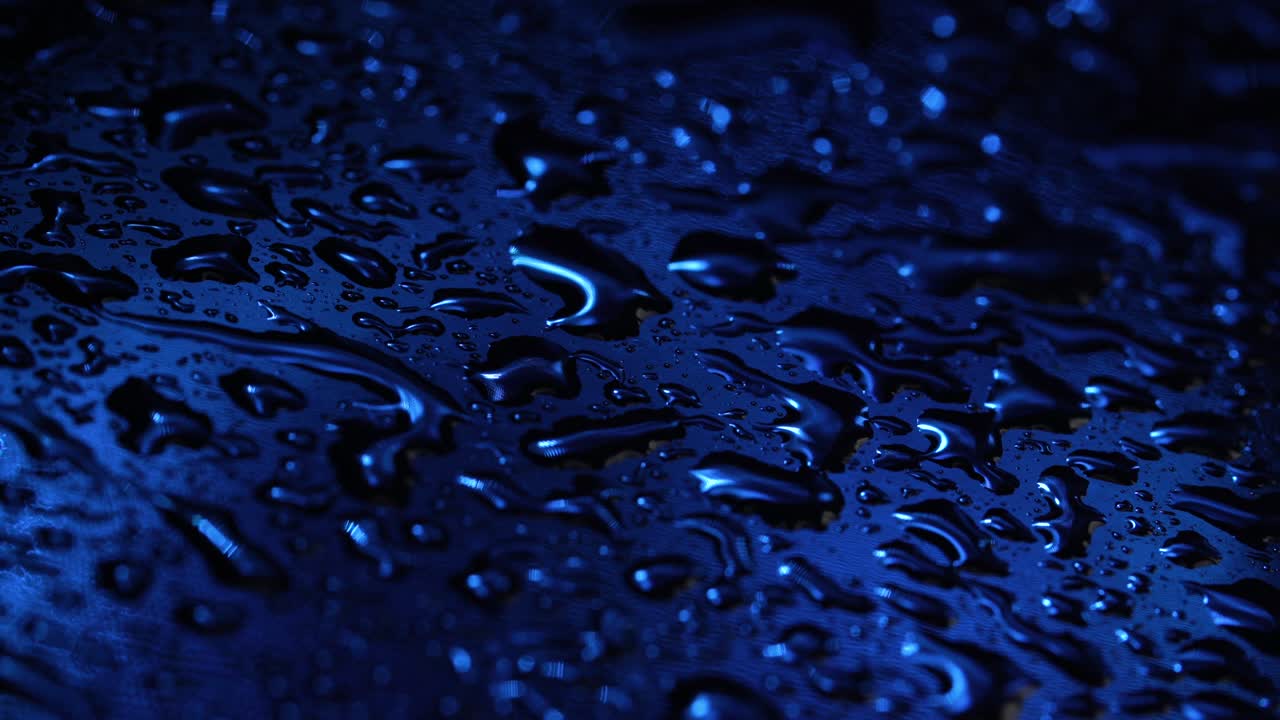 imágenes de gotas de líquido en vidrio azul oscuro