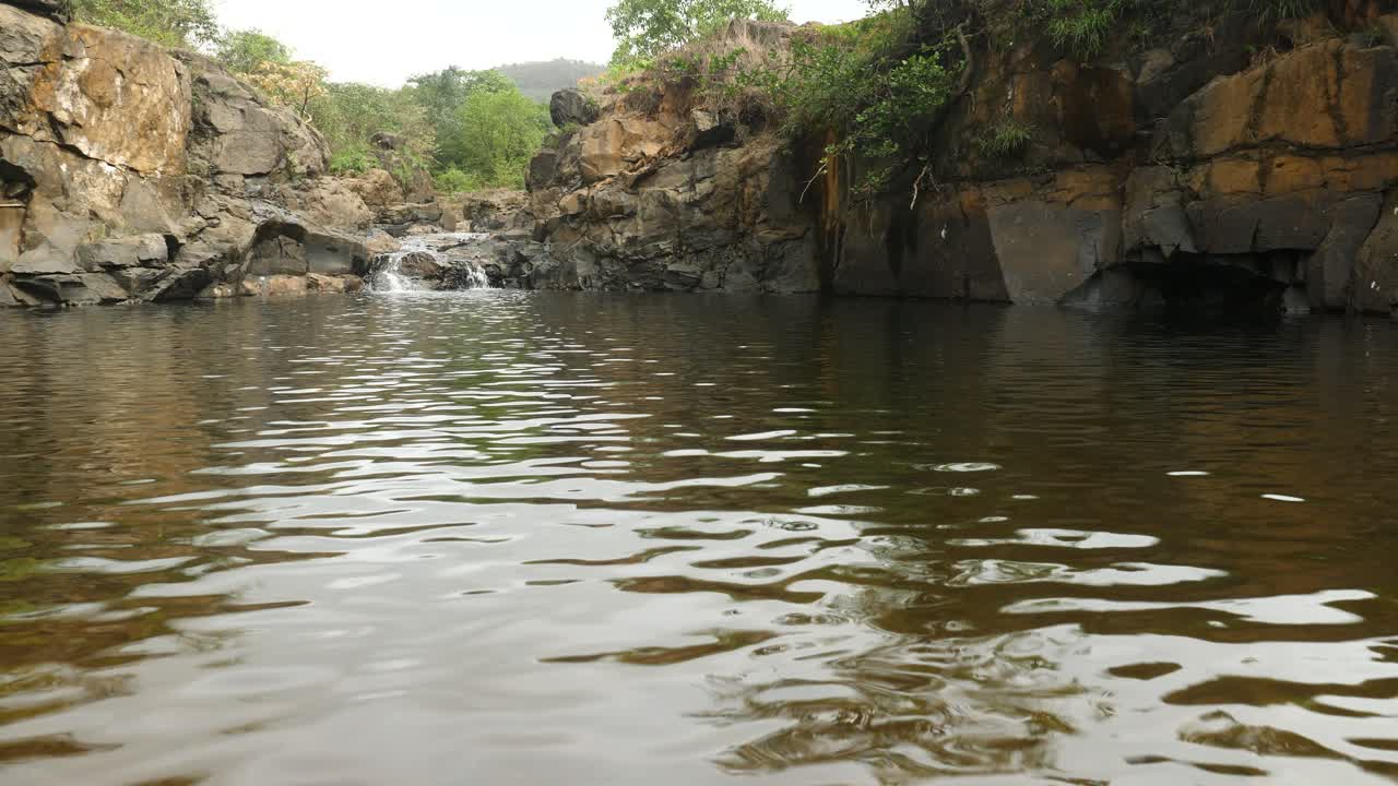 una piscina aislada con ondas formadas en la superficie en medio de un denso bosque lleno de agua en medio de los veranos un refugio para la vida silvestre durante el duro verano, ghats occidentales, india