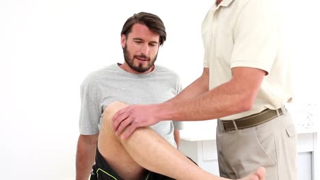 physical therapist checking patients knee