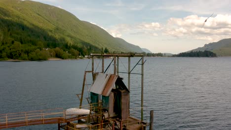 old abandoned wharf on a lake with mountains in background