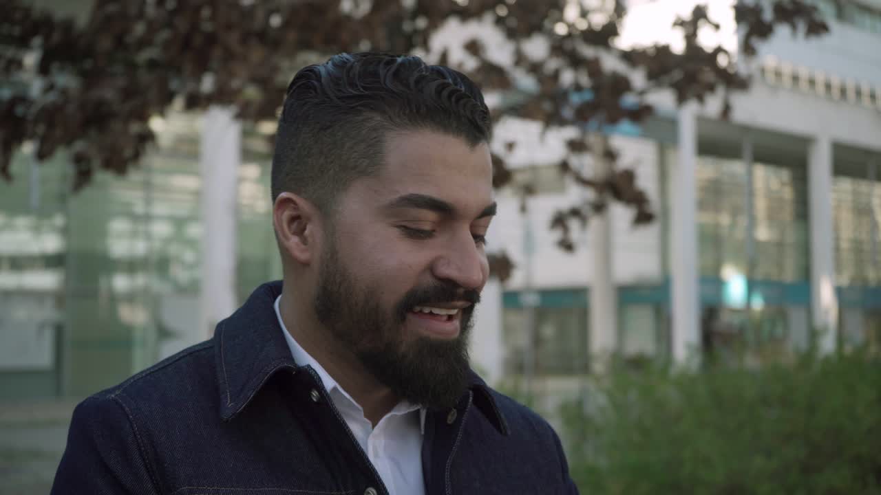 hombre barbudo usando una tableta y riendo