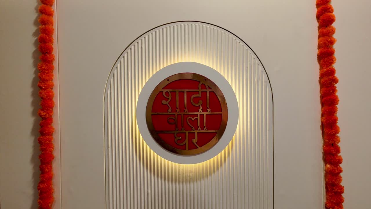 Beautiful 4K stock footage of 'Shaadi Wala Ghar' wedding decoration entrance with glowing text, floral garlands and elegant backdrop. Indian marriage themes, event setups, festive celebrations.