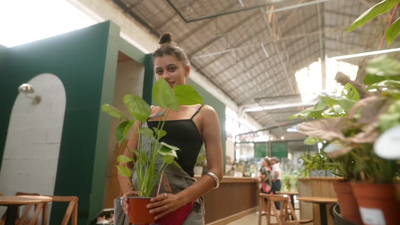 Woman Holding Indoor Plants in a Nursery
