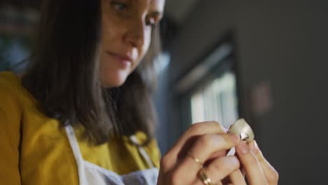 Close-up-of-caucasian-female-jeweller-carefully-checking-piece-of-jewelry